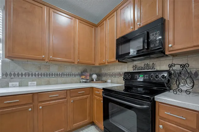 a kitchen with granite countertop a stove sink and cabinets