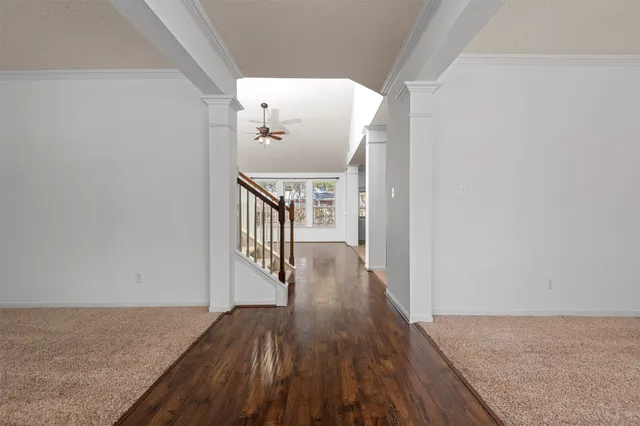 a view of a hallway with wooden floor