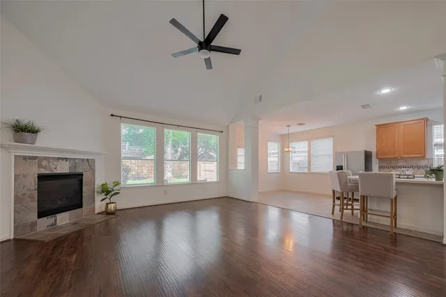 a view of an empty room with wooden floor fireplace and a window