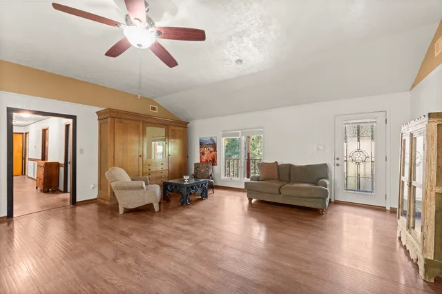 a living room with furniture and a wooden floor