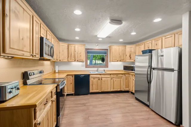 a kitchen with a refrigerator a sink and wooden cabinets
