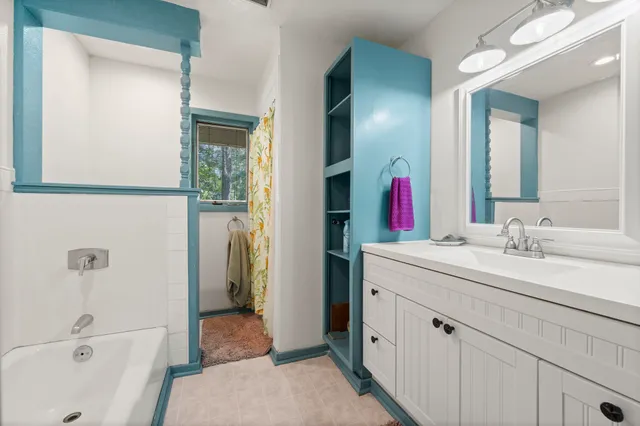 a en suite bathroom with a double vanity sink a mirror and a bathtub