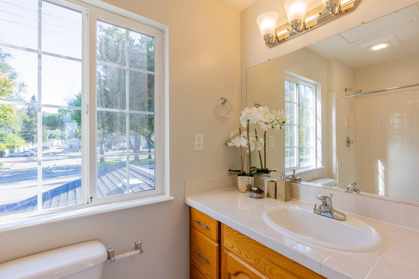 1069 East Homestead Road Sunnyvale, CA 94087 - Photo 28 of 36 a bathroom with a granite countertop sink a large mirror and a window