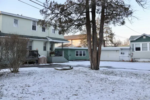 a view of a house with backyard and a tree