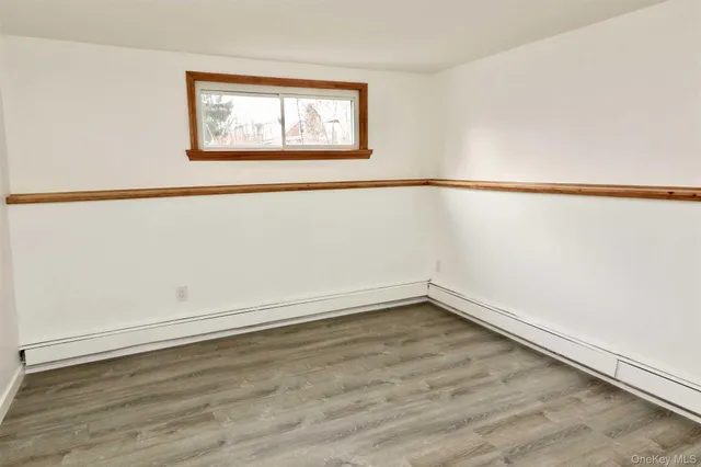 an empty room with wooden floor and window