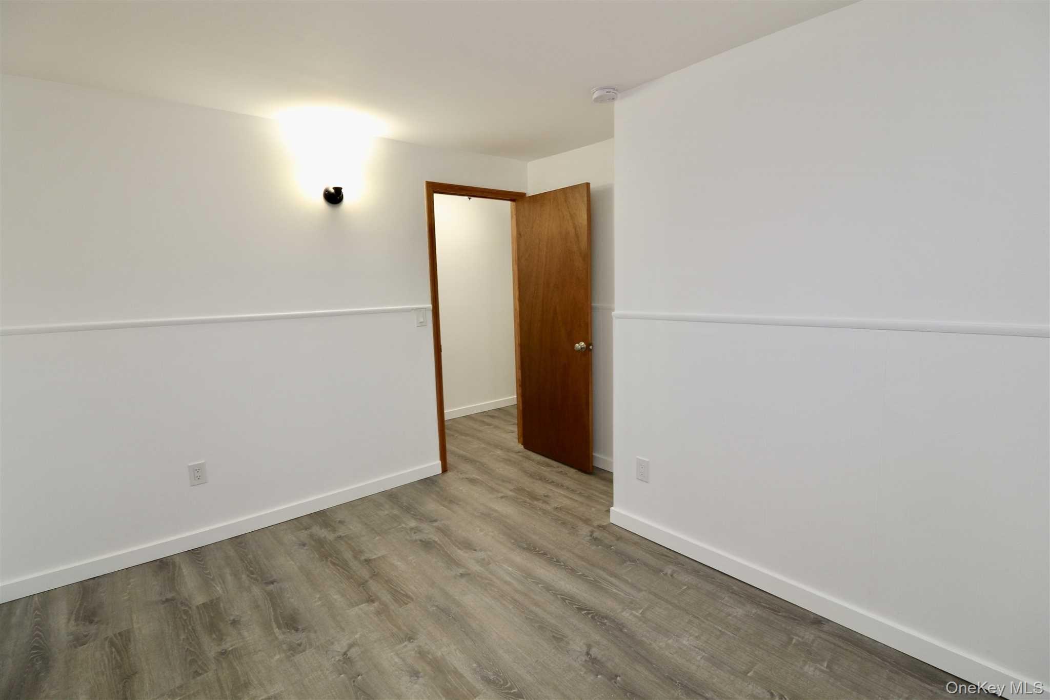 128 Catherine Street, Unit A Beacon, NY 12508 - Photo 16 of 18 an empty room with wooden floor and mirror