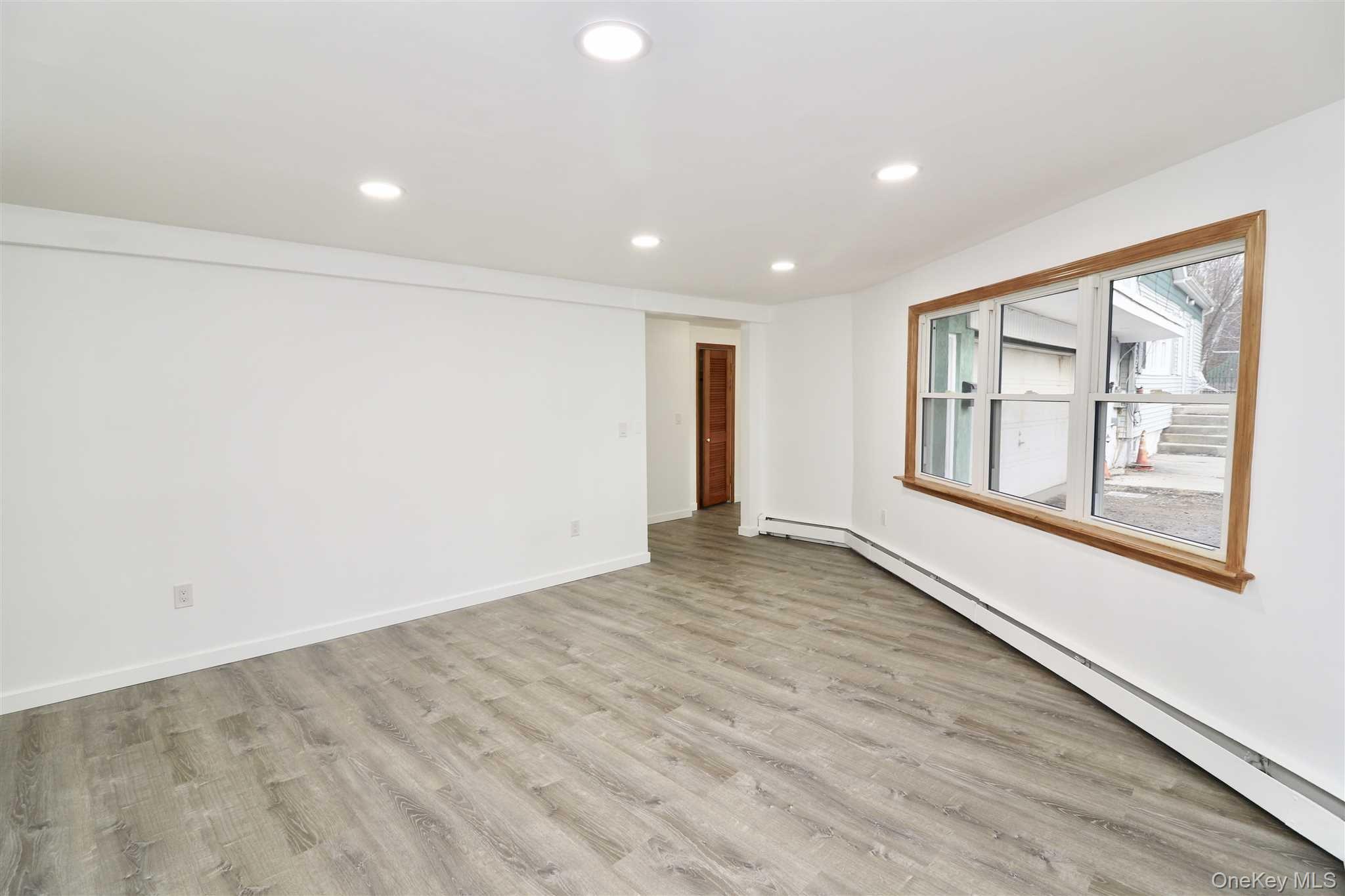 128 Catherine Street, Unit A Beacon, NY 12508 - Photo 3 of 18 an empty room with wooden floor and windows