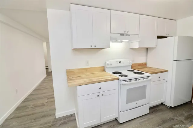 a kitchen with white cabinets and white appliances
