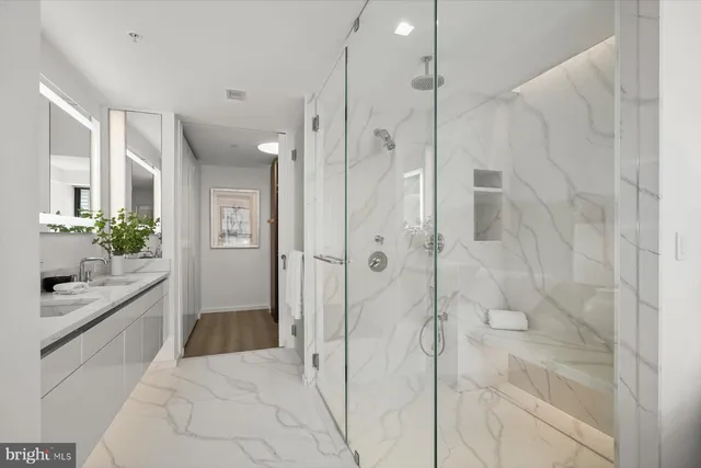 a spacious bathroom with a granite countertop shower a sink and a mirror