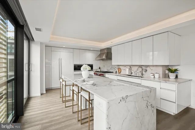a kitchen with a stove a refrigerator white cabinets and wooden floor