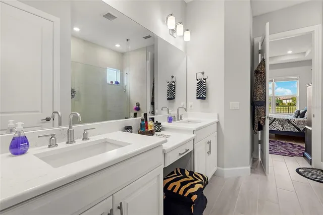 a en suite bathroom with a sink double vanity and a shower