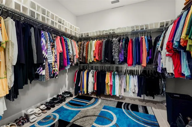 a view of walk in closet with clothes and shoes