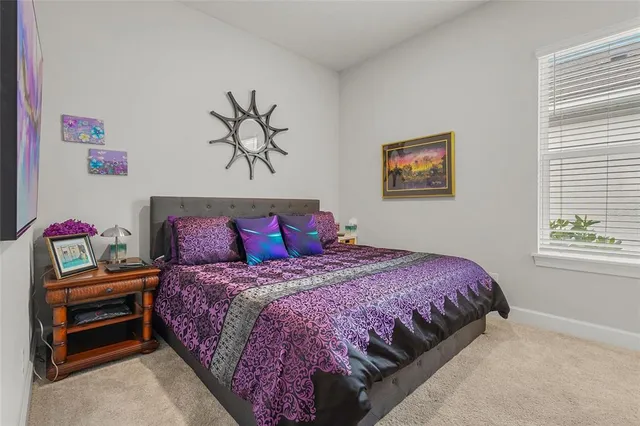 a bedroom with a bed and a painting on the wall