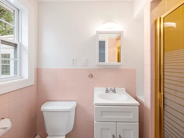a bathroom with a toilet sink and mirror
