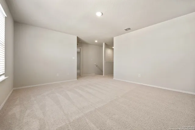 an empty room with windows and entrance to other room