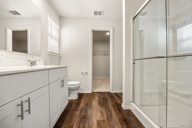 a bathroom with a sink a toilet and a large mirror