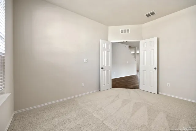 an empty room with an entryway and window