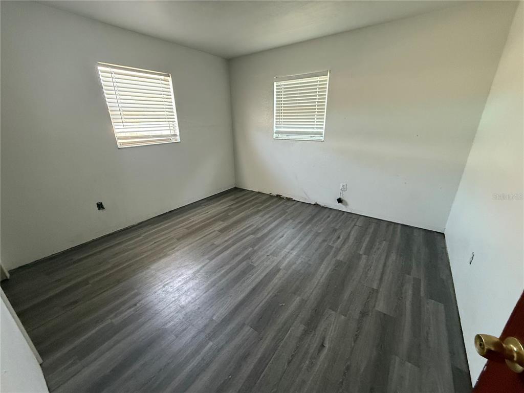 1129 Southwest Golden Avenue Arcadia, FL 34266 - Photo 14 of 25 a view of an empty room with wooden floor and a window