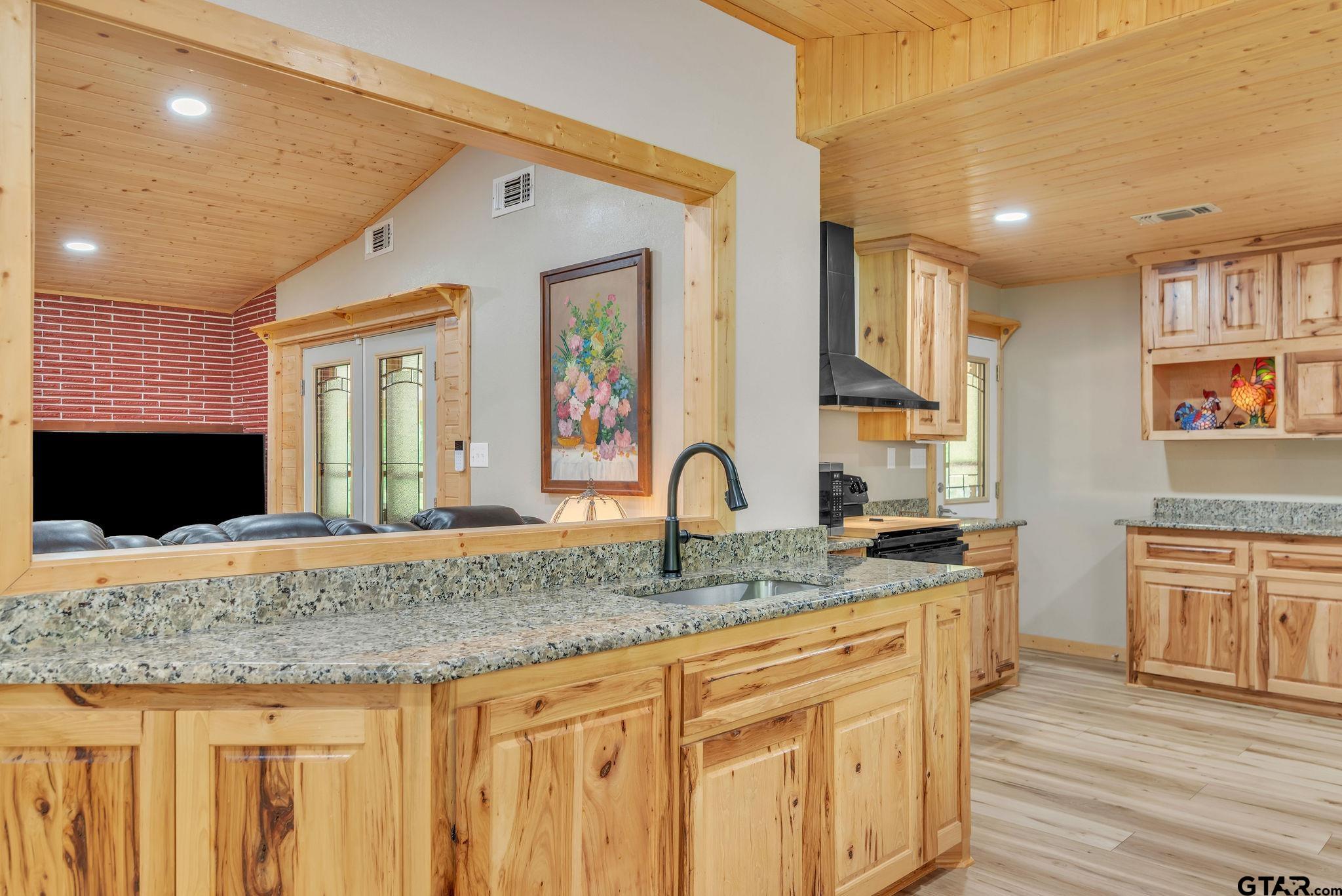 519 E Well Naples, TX 75568 - Photo 11 of 48 a kitchen with granite countertop a sink and cabinets
