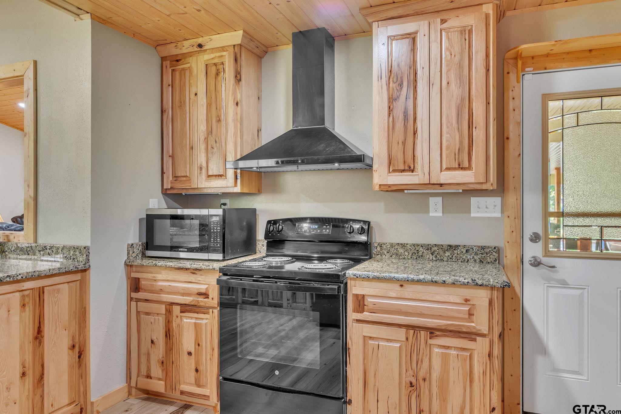519 E Well Naples, TX 75568 - Photo 13 of 48 a kitchen with stainless steel appliances granite countertop a stove a sink and a microwave