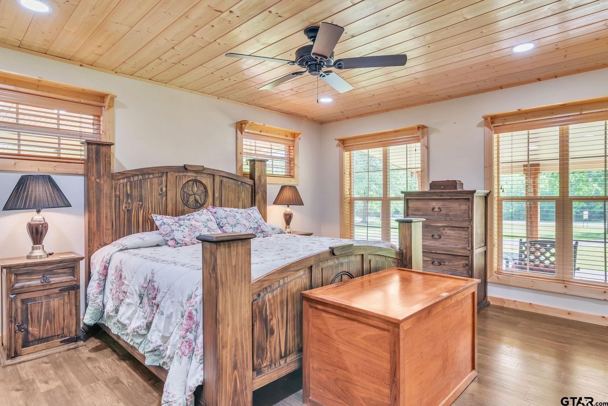 519 E Well Naples, TX 75568 - Photo 15 of 48 a bedroom with a bed a chandelier and large windows