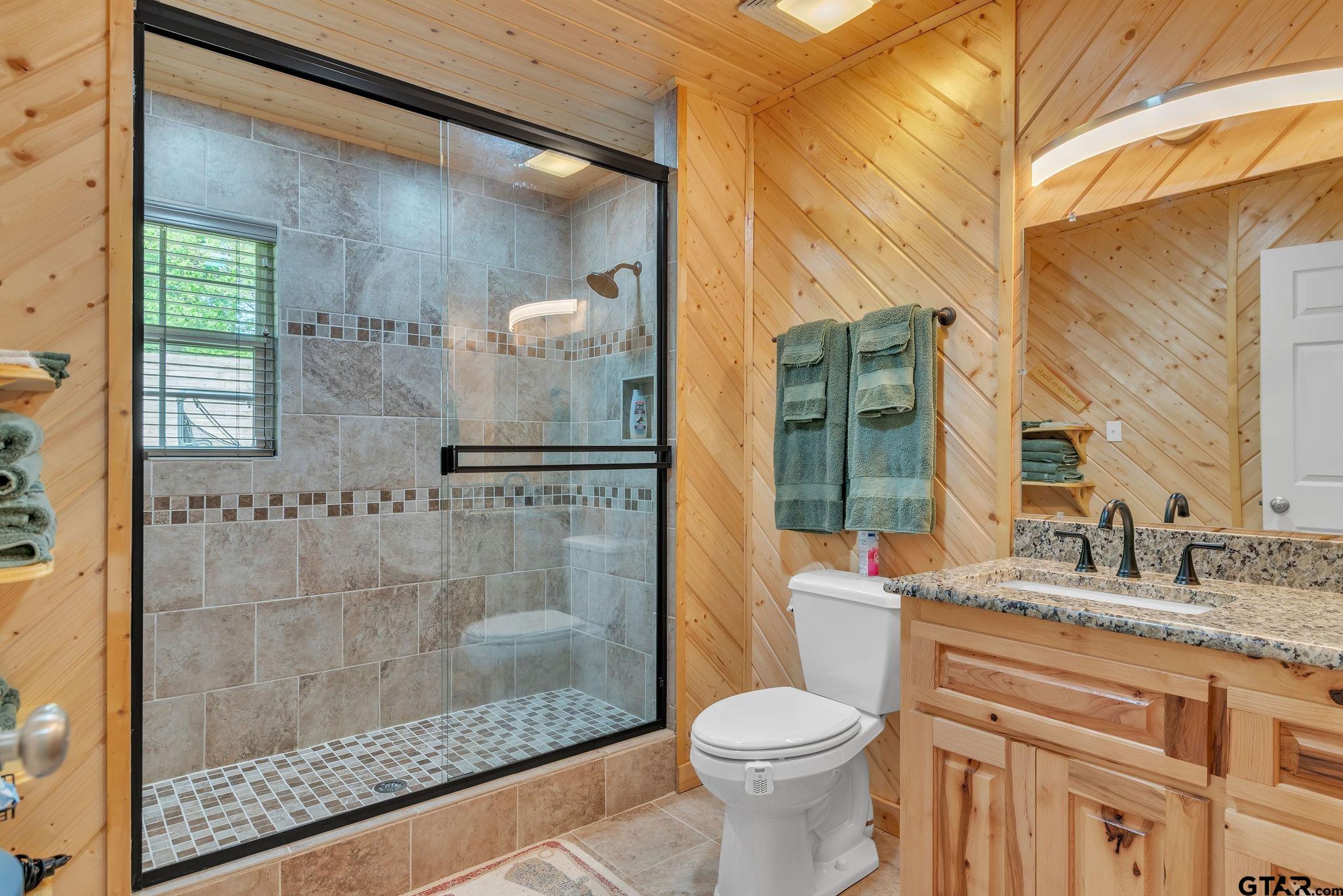 519 E Well Naples, TX 75568 - Photo 22 of 48 a bathroom with a granite countertop sink toilet and shower