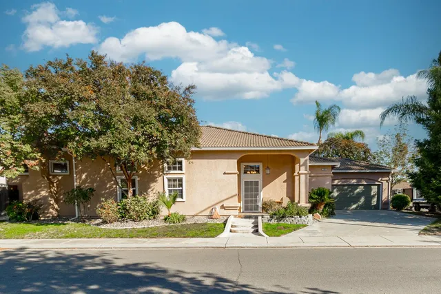 a view of a house with a backyard and a tree