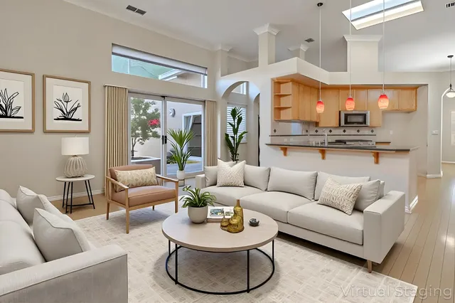a living room with furniture kitchen view and a large window