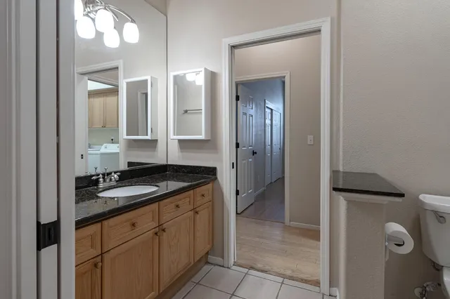 a spacious bathroom with a granite countertop sink mirror and toilet
