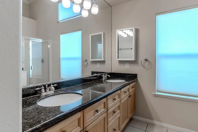 a bathroom with a granite countertop sink double and mirror