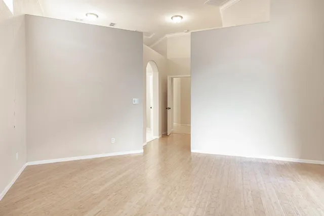 a view of an empty room with wooden floor