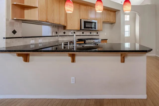 a view of kitchen with stainless steel appliances granite countertop refrigerator sink and microwave