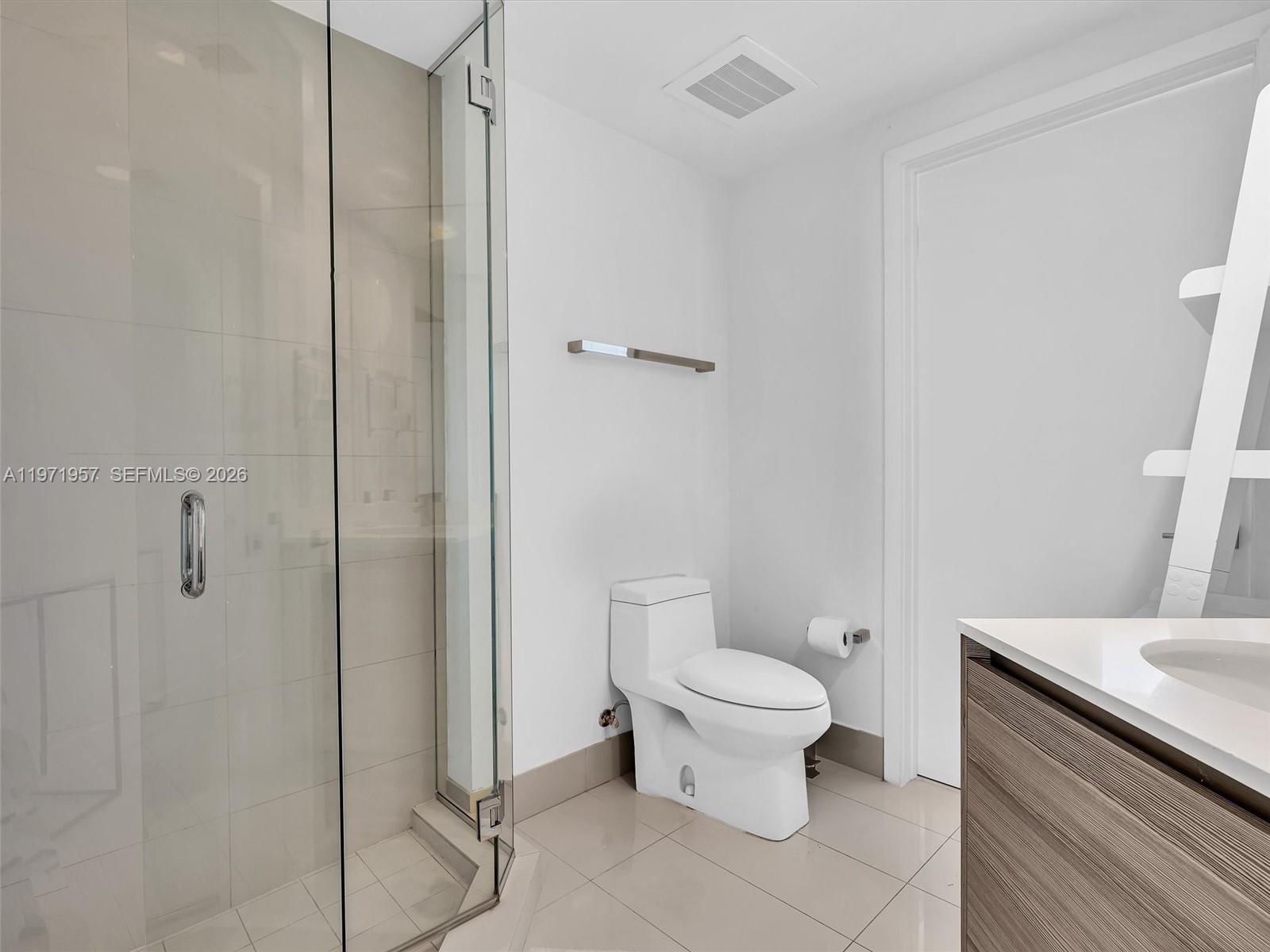 121 Northeast 34th Street, Unit 2016 Miami, FL 33137 - Photo 11 of 55 a bathroom with a granite countertop toilet and a shower