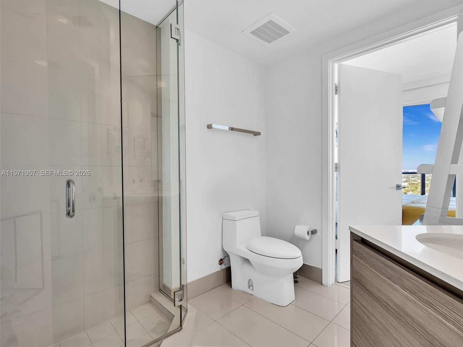 121 Northeast 34th Street, Unit 2016 Miami, FL 33137 - Photo 12 of 55 a bathroom with a granite countertop toilet and a shower