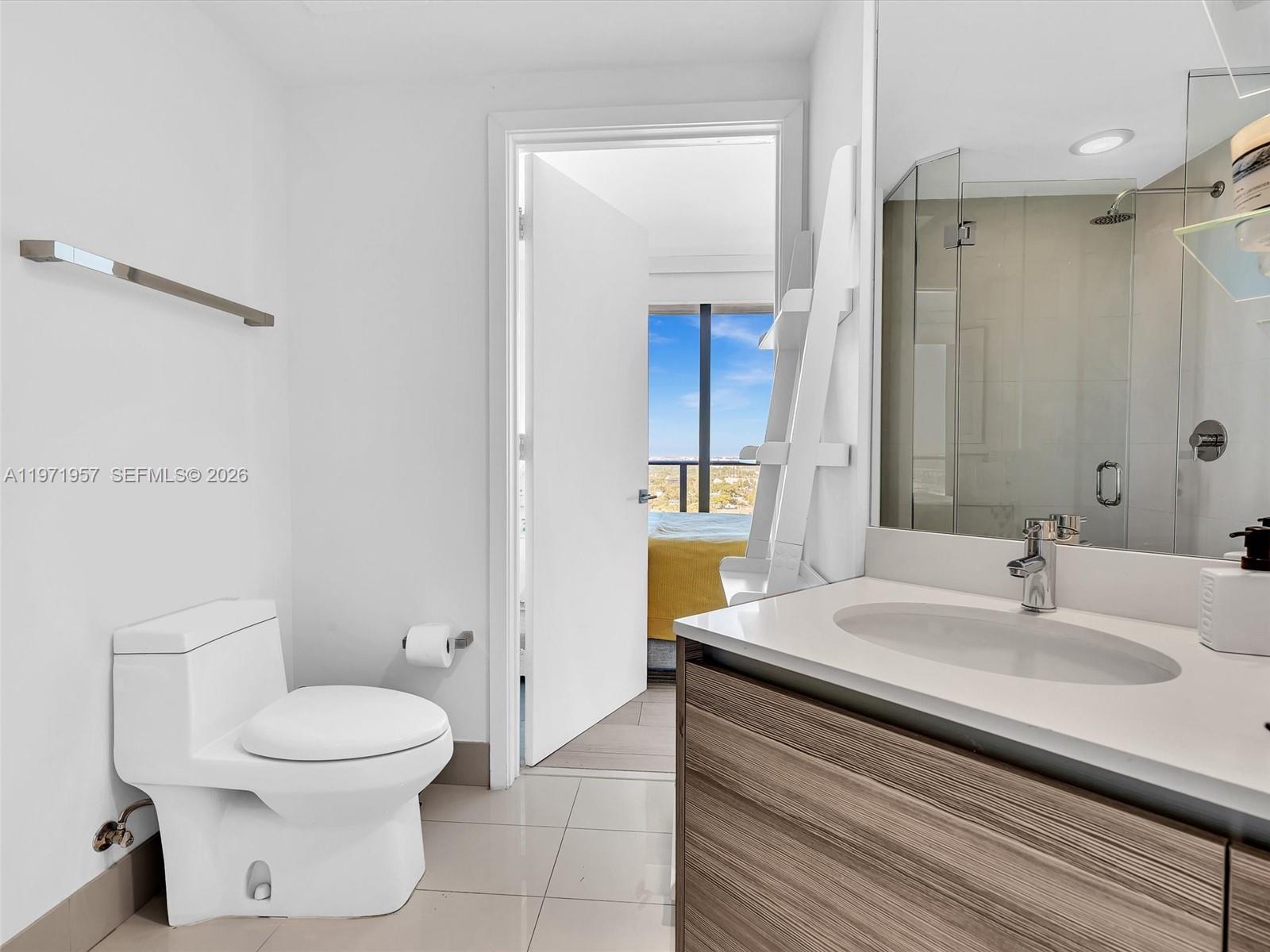 121 Northeast 34th Street, Unit 2016 Miami, FL 33137 - Photo 13 of 55 a bathroom with a sink a toilet and a mirror