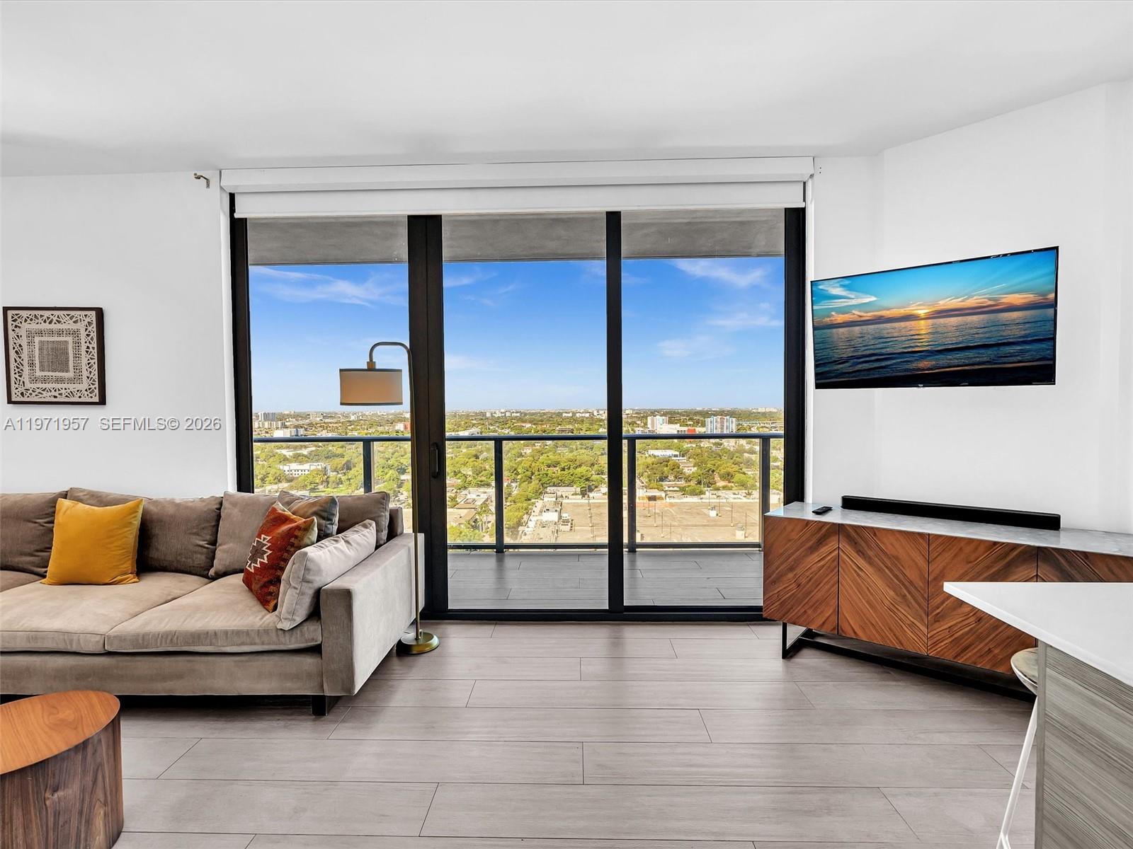 121 Northeast 34th Street, Unit 2016 Miami, FL 33137 - Photo 15 of 55 a living room with furniture and a flat screen tv