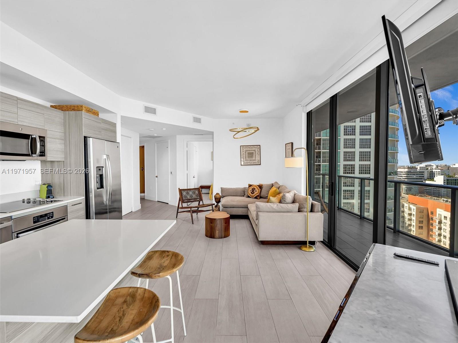 121 Northeast 34th Street, Unit 2016 Miami, FL 33137 - Photo 33 of 55 a living room with furniture and a flat screen tv