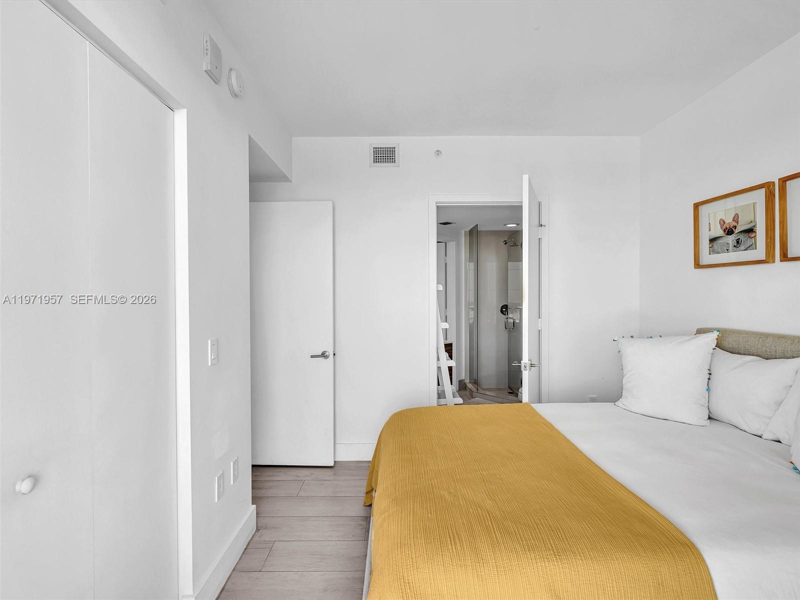 121 Northeast 34th Street, Unit 2016 Miami, FL 33137 - Photo 38 of 55 a bedroom with a bed and a painting on the wall