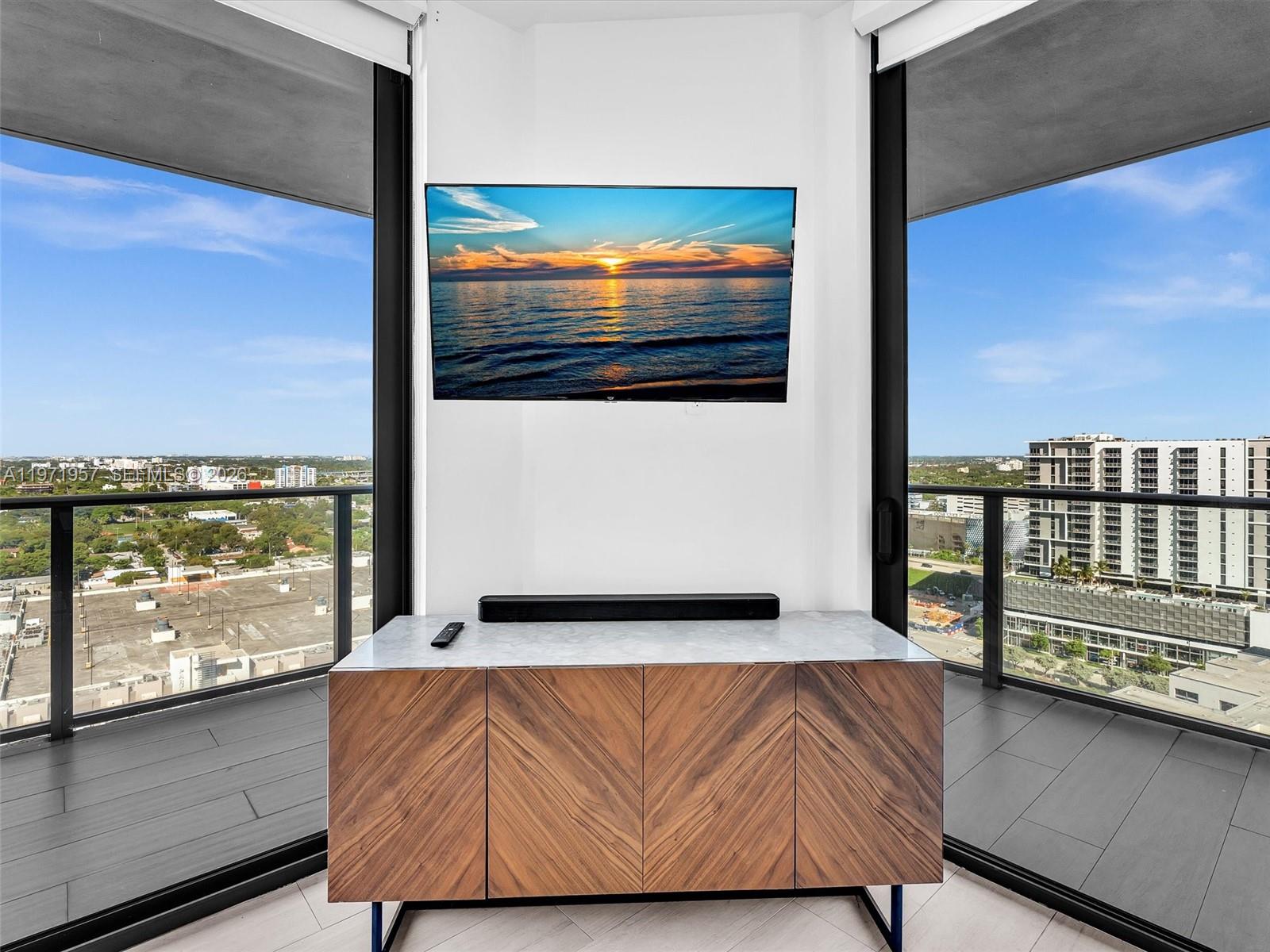 121 Northeast 34th Street, Unit 2016 Miami, FL 33137 - Photo 10 of 55 a living room with a large window and a flat screen tv