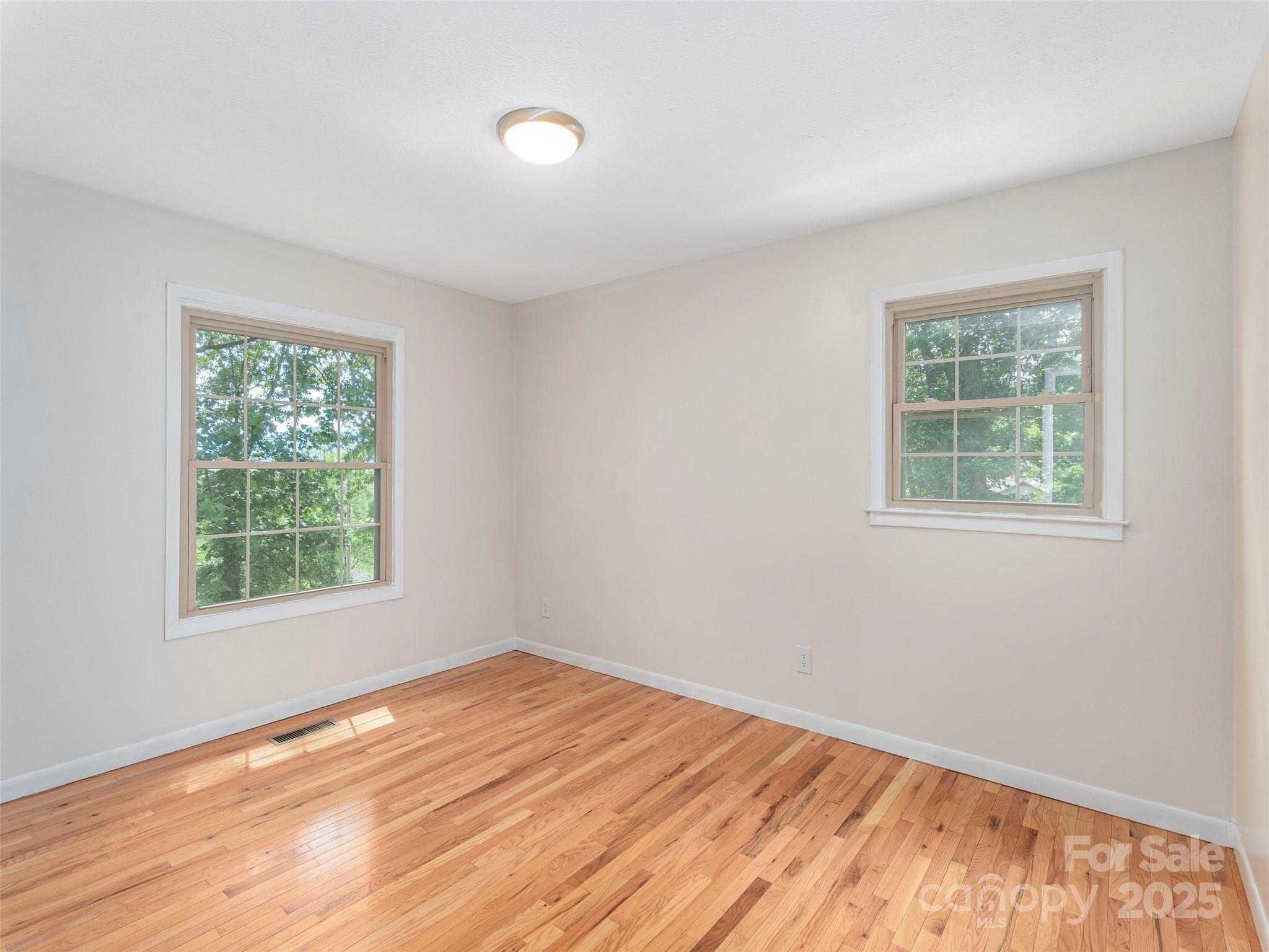 623 Nellie John Drive Clyde, NC 28721 - Photo 14 of 25 a view of an empty room with wooden floor and a window