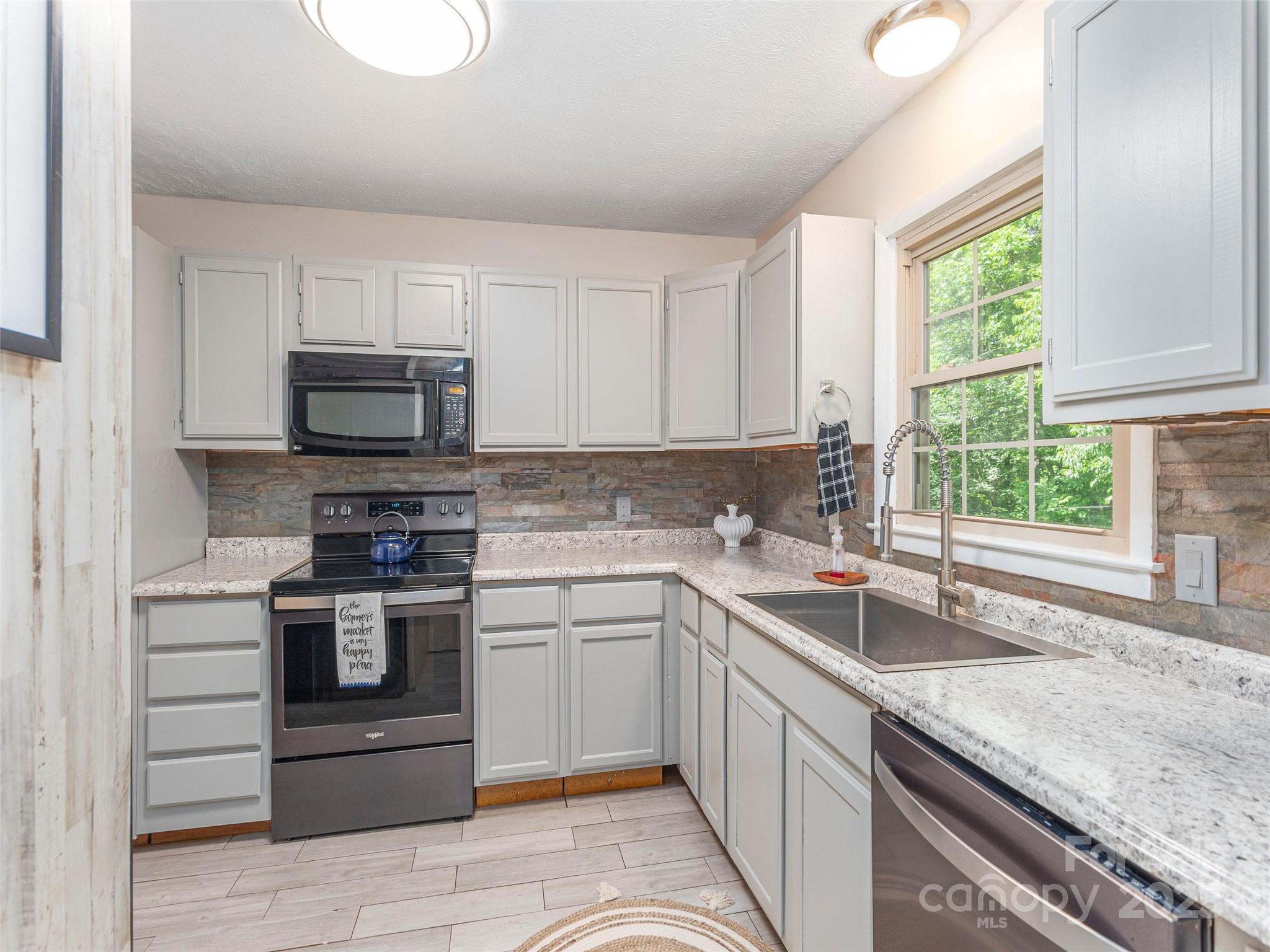 623 Nellie John Drive Clyde, NC 28721 - Photo 10 of 25 a kitchen with a sink stove and microwave