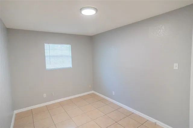 an empty room with white walls and tiles