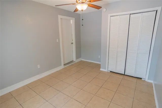 a view of an empty room and chandelier fan