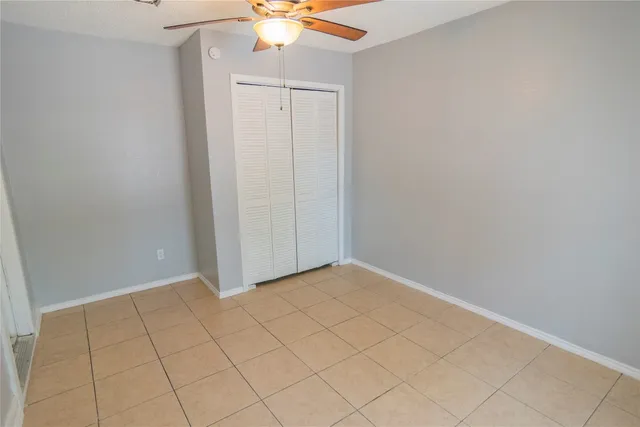 an empty room with chandelier fan