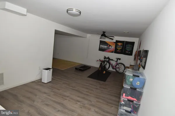 a room with chandelier fan and wooden floor