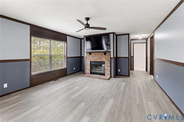 a view of empty room with a fireplace and a window
