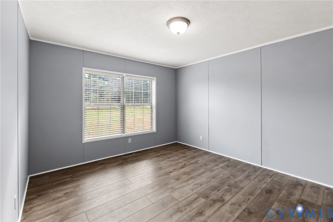11391 Watkins Road Rockville, VA 23146 - Photo 17 of 28 an empty room with wooden floor and windows