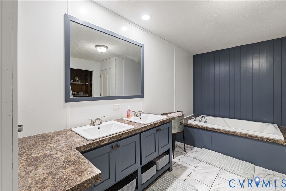 11391 Watkins Road Rockville, VA 23146 - Photo 22 of 28 a bathroom with a tub sink and mirror