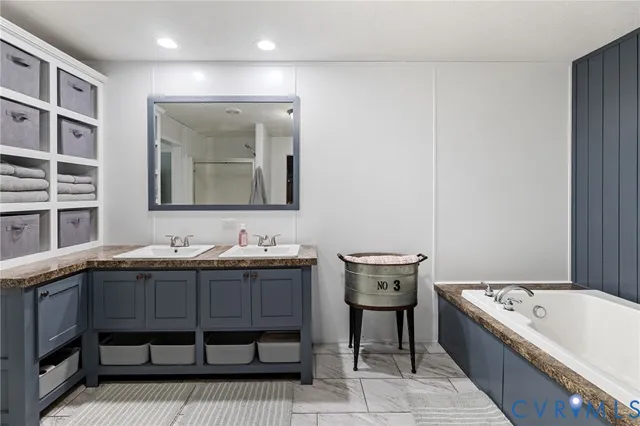 a bathroom with a tub sink and mirror