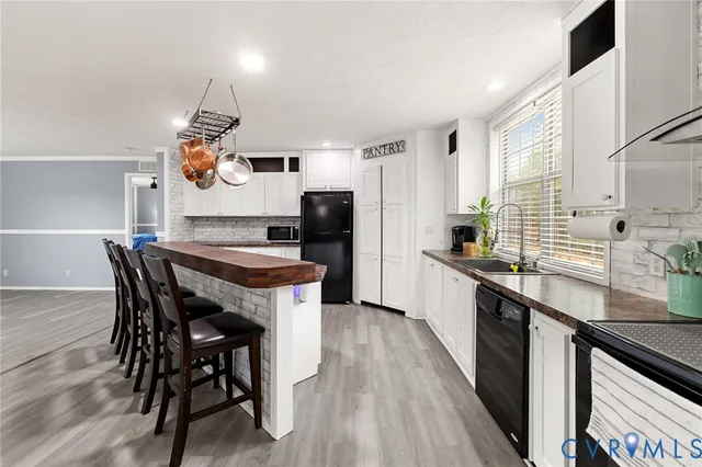 a kitchen with stainless steel appliances kitchen island granite countertop a table chairs in it and wooden floors